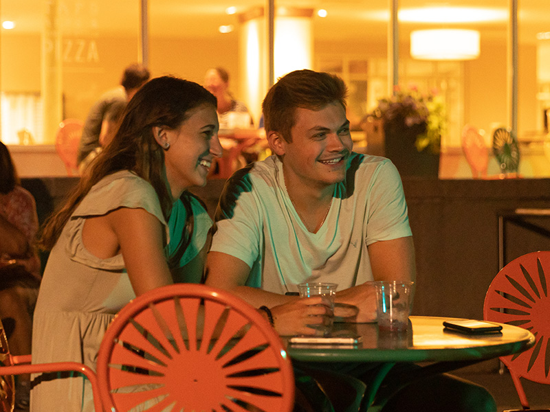 Two people sitting on the Memorial Union Terrace at night.