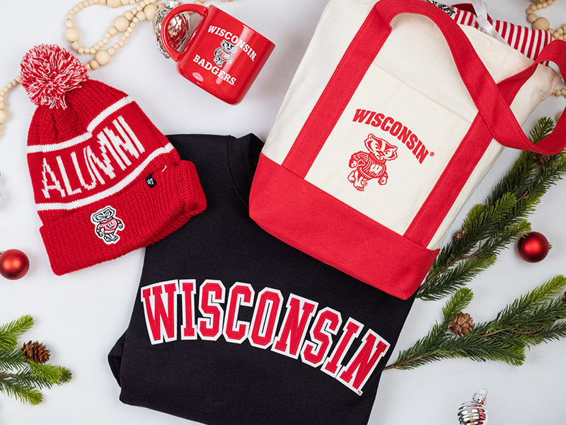 Some of the items available from the UW Alumni Store - a red Alumni beanie hat, a red Wisconsin Badgers mug, a white and red Wisconsin canvas tote bag and a Wisconsin sweatshirt.