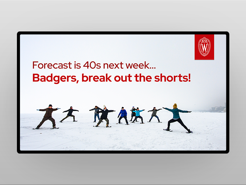 Sample digital screen featuring group of people wearing snow shoes and winter gear on lake with overlay red text that reads, Forecast is 40s next week...Badgers, break out the shorts!