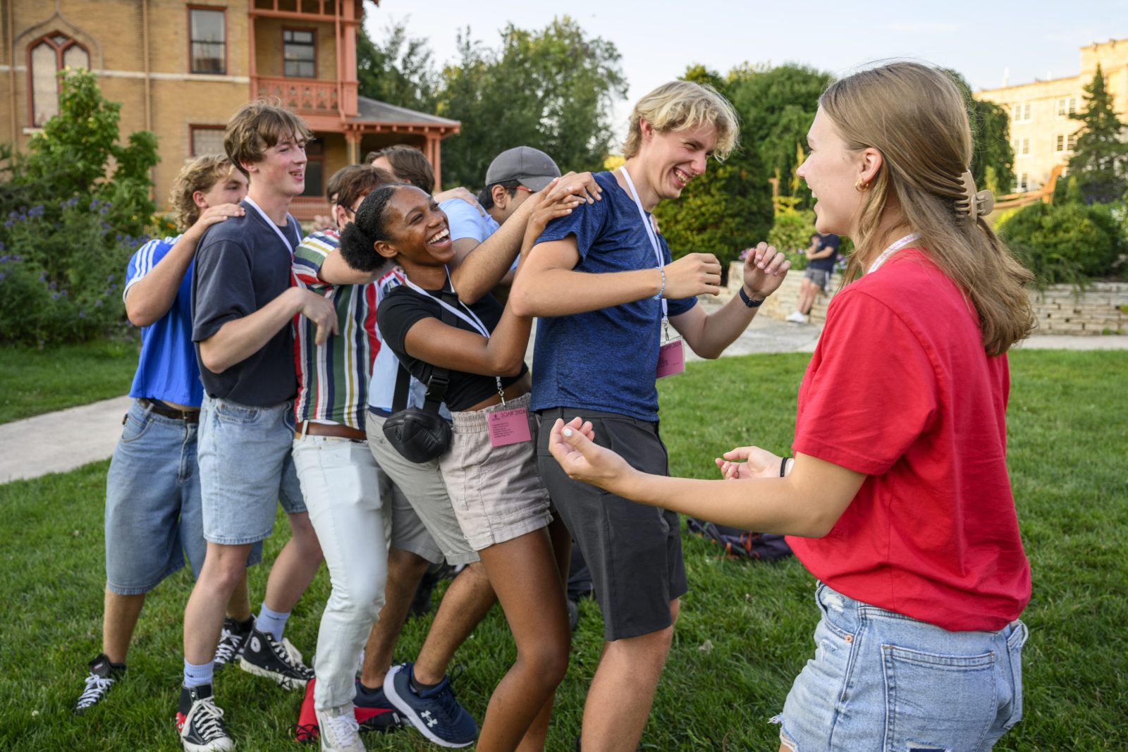 Group of students smiling and laughing while participating in ice breaker activity.
