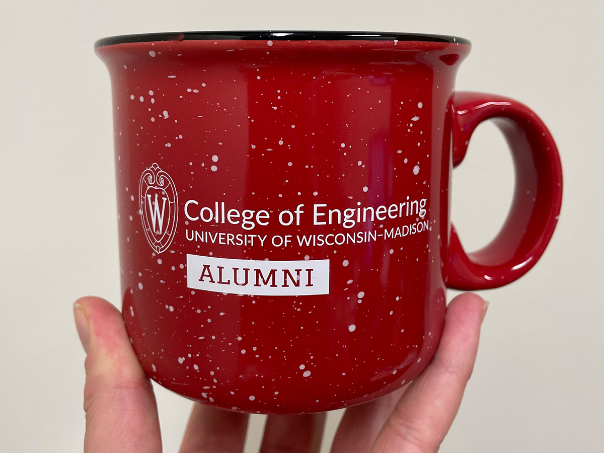 A red speckled mug with the University of Wisconsin-Madison College of Engineering logo and the word 'Alumni' printed on it.