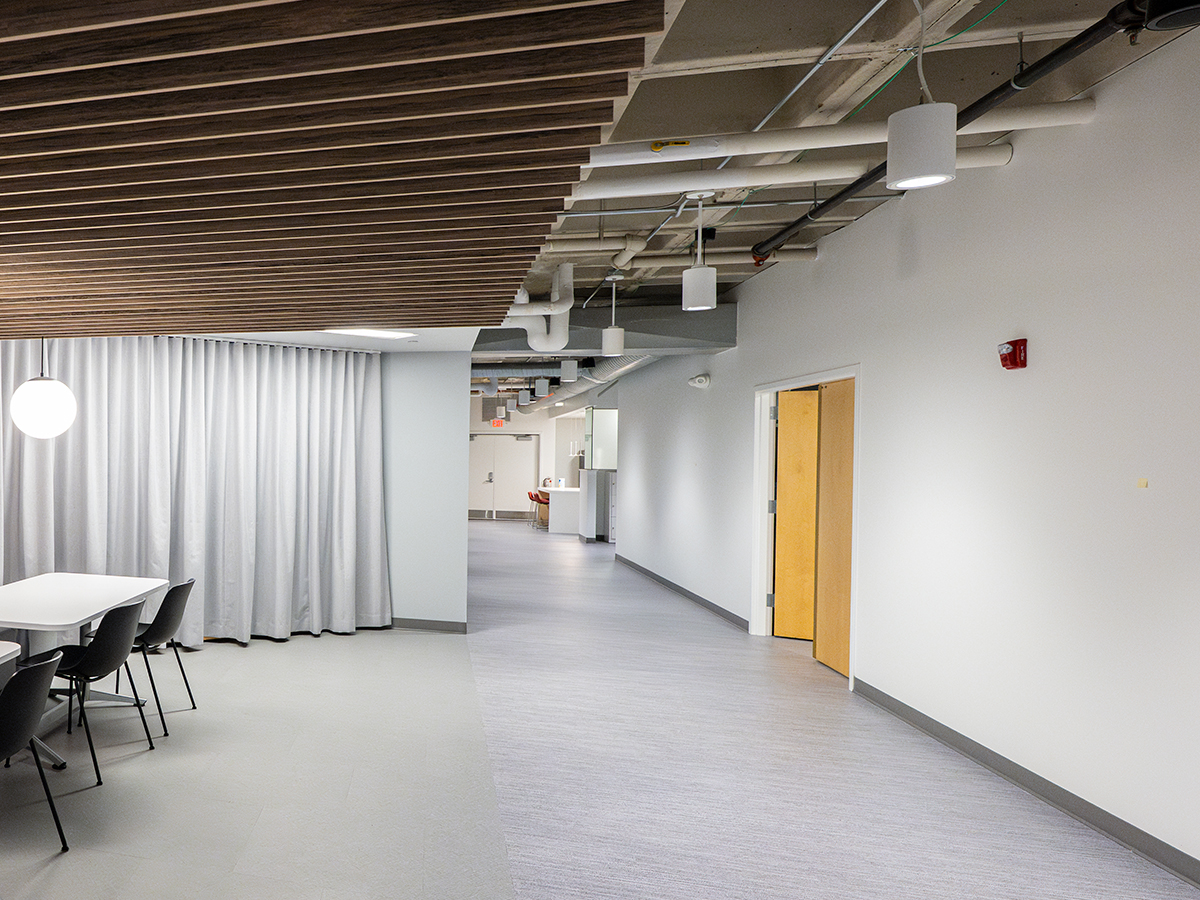 Before photo of a blank wall on the right while looking down a hallway