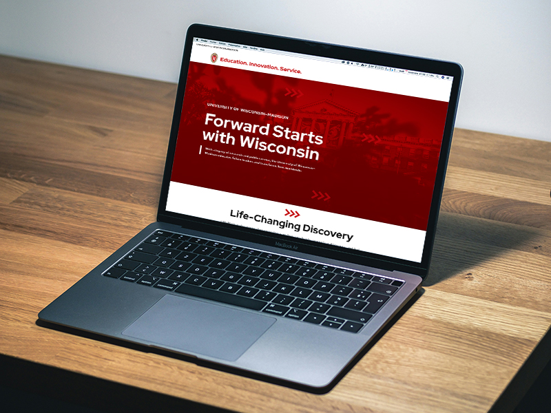 Laptop showing a website with the heading "Forward Starts with Wisconsin"