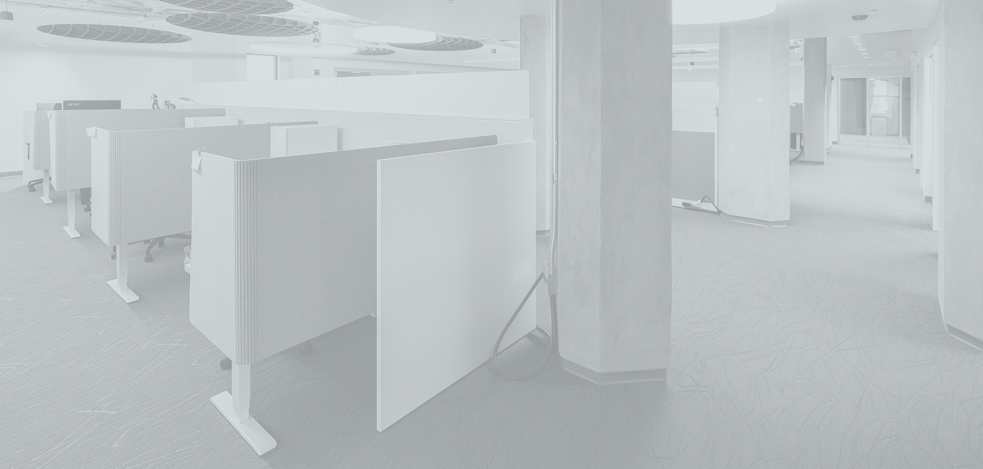 Gray interior of an office space with cubicles and a corridor