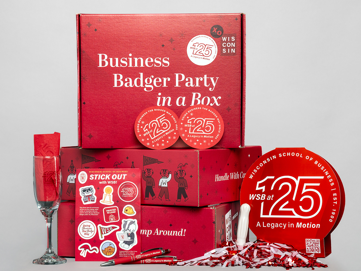 A stack of red boxes and Wisconsin School of Business 125th anniversary decor.