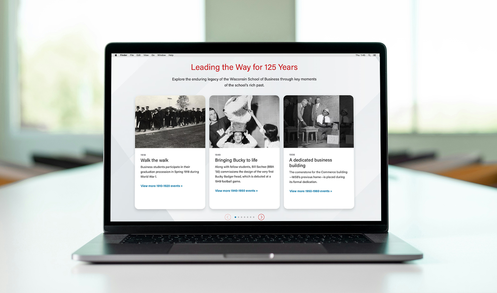 Laptop on a table showing a website page with black and white photos of people